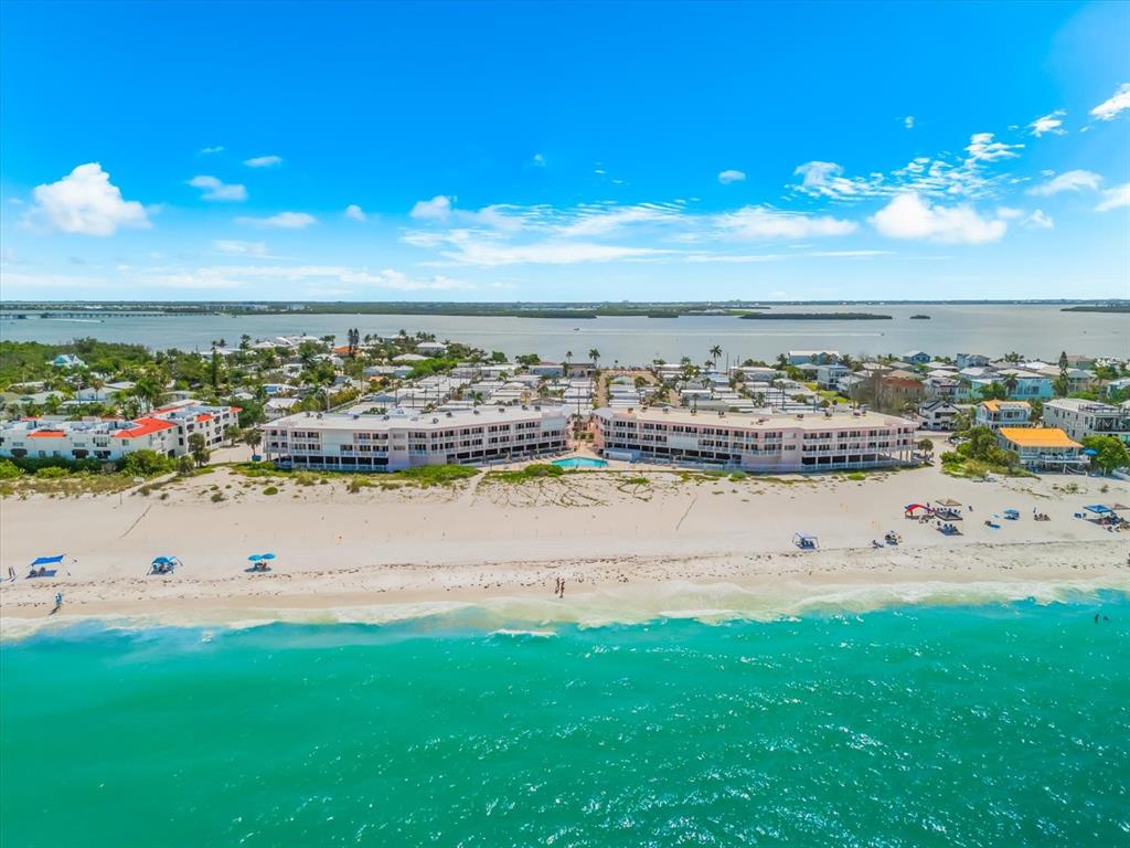 An aerial view of a beachfront apartment complex with a pool on a sunny day — 2600 GULF DRIVE N UNIT 33, BRADENTON BEACH, FL