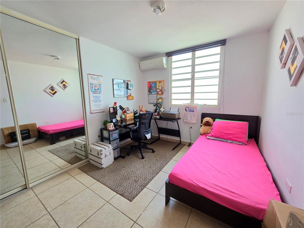 A bedroom features a twin bed with pink bedding, a desk, and mirrored closet doors — 838 IMPERIAL, JUANA DIAZ, PR