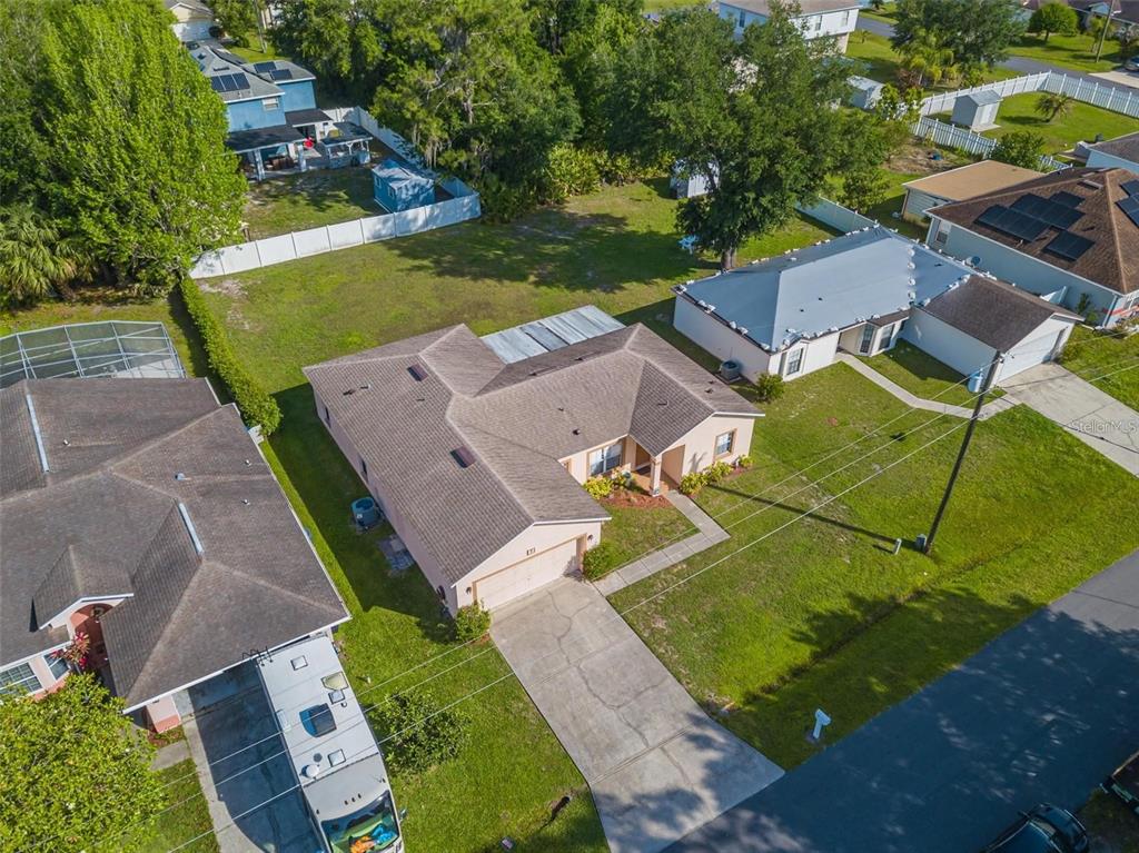 An aerial view shows a suburban house with a tan exterior and a shingled roof — 7 TAMIAMI WAY, KISSIMMEE, FL