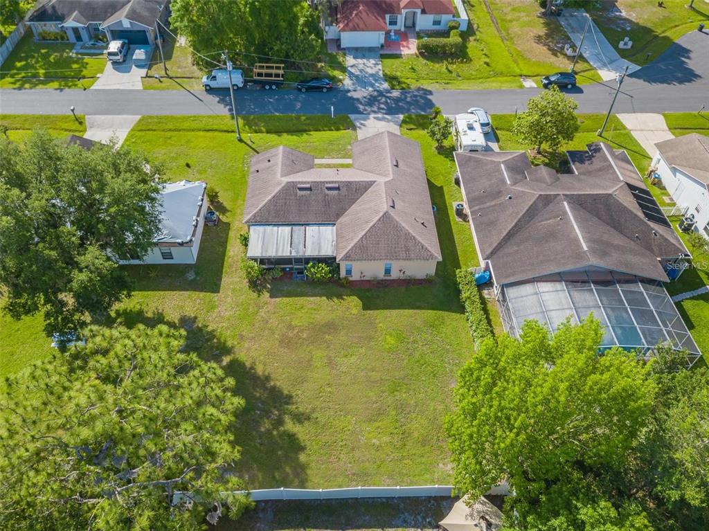 An aerial view shows a residential house with a large backyard and a screened patio — 7 TAMIAMI WAY, KISSIMMEE, FL