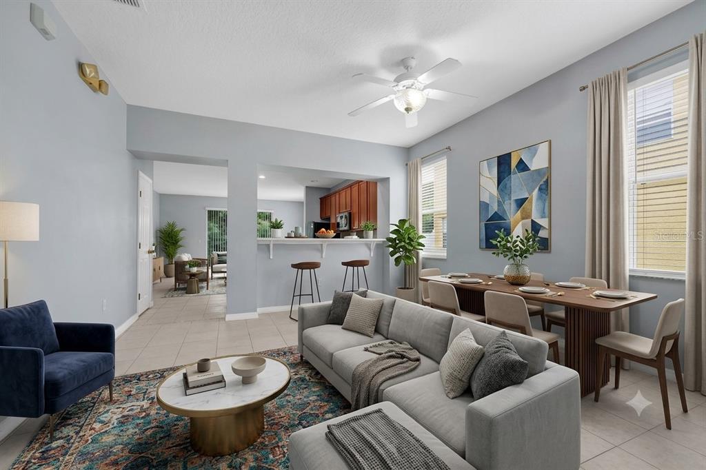 A living and dining area with a grey sofa, blue armchair, and kitchen breakfast bar — 5266 PARADISE CAY CIRCLE, KISSIMMEE, FL