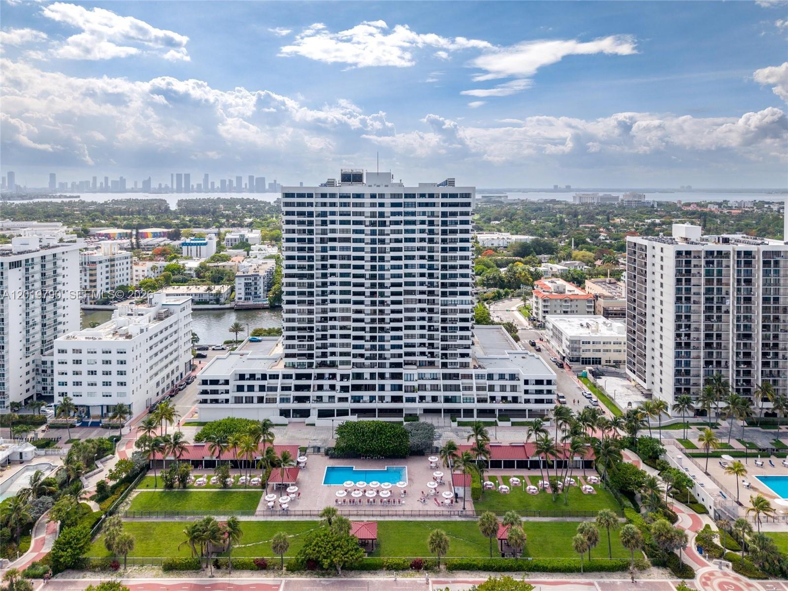 An aerial view shows a tall residential building with a pool and landscaped grounds — 2555 Collins Ave # 1003, Miami Beach FL 33140, MIAMI BEACH, FL