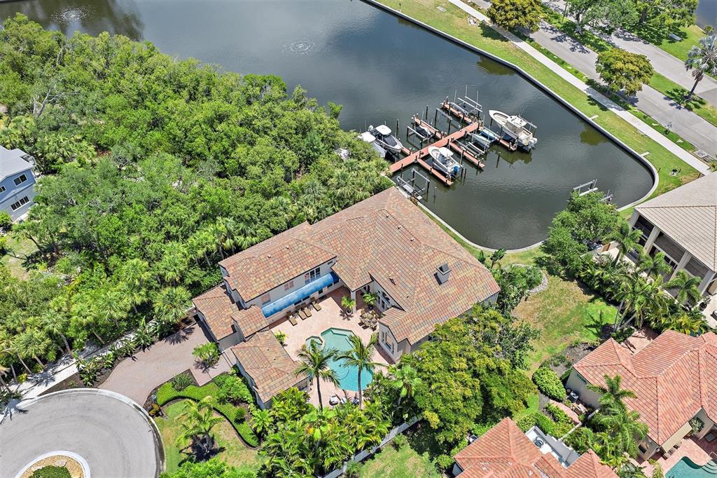 An aerial view shows a house with a pool and a private boat dock — 617 WESTON POINTE COURT, LONGBOAT KEY, FL