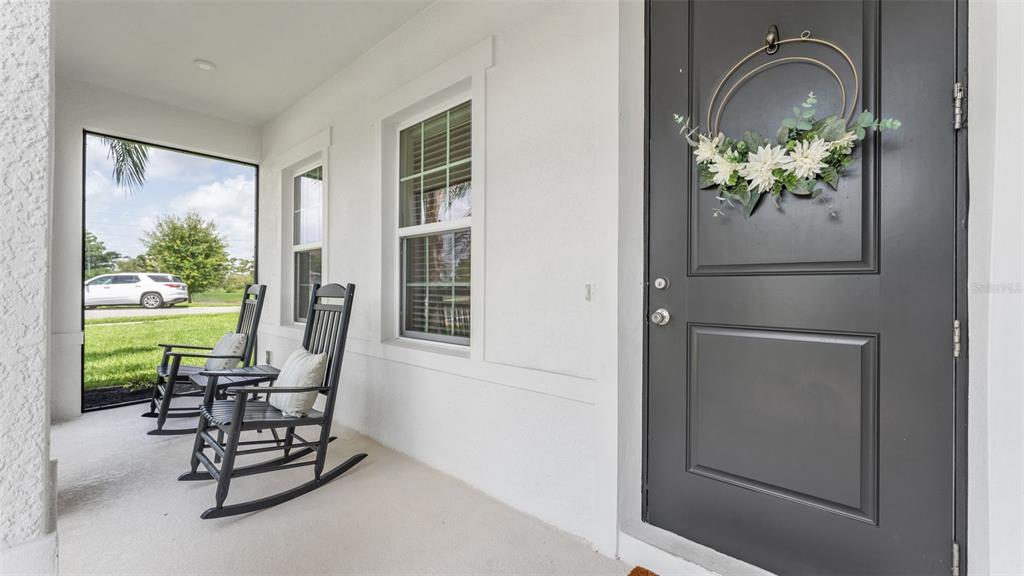 A covered front porch features two black rocking chairs and a dark front door — 3205 LA SALLE STREET, WINTER HAVEN, FL