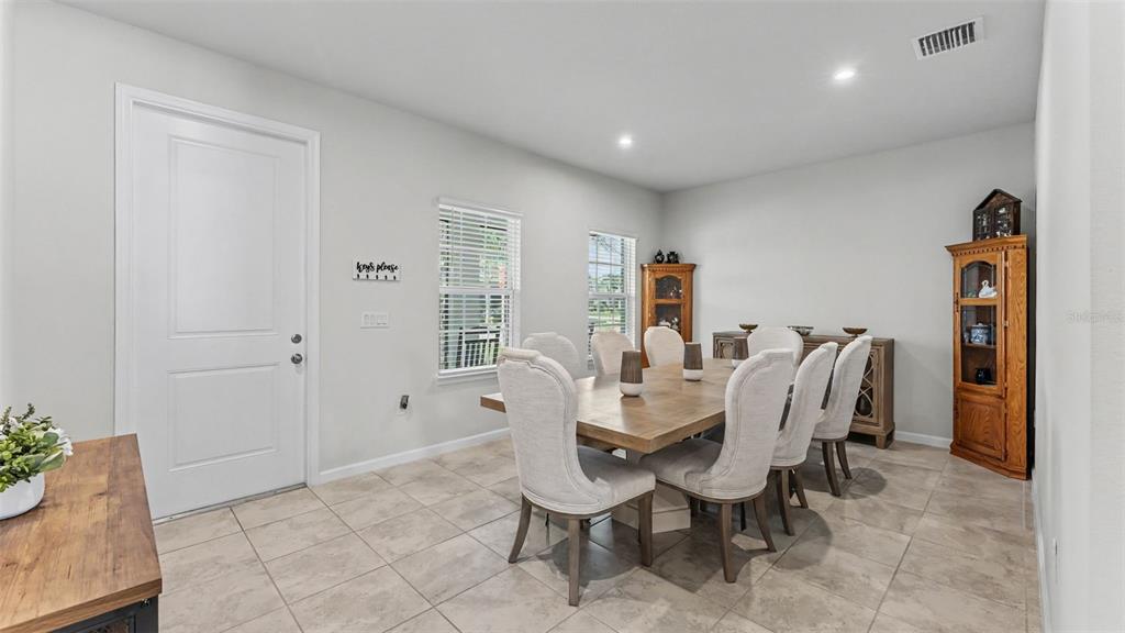 A dining room features a wooden table with six upholstered chairs and two wooden cabinets — 3205 LA SALLE STREET, WINTER HAVEN, FL