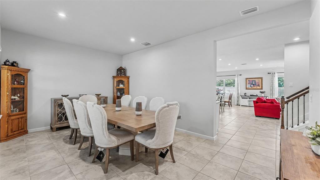 A dining room with a wooden table and chairs sits adjacent to a living area — 3205 LA SALLE STREET, WINTER HAVEN, FL