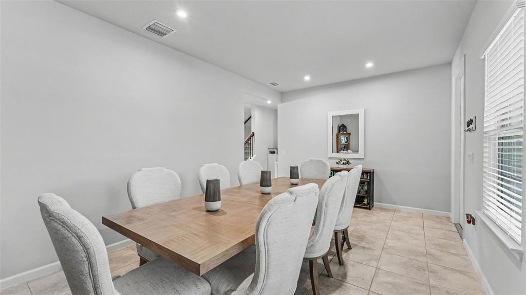 A dining room features a wooden table, six upholstered chairs, and light-colored tile flooring — 3205 LA SALLE STREET, WINTER HAVEN, FL