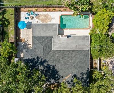 An aerial view shows a house with a dark shingled roof, a pool, and patio — 1950 REBECCA DRIVE, CLEARWATER, FL