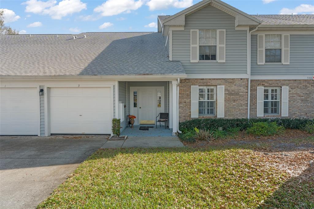 A two-story townhouse with a brick and light blue siding exterior and a garage — 5300 DOVER VILLAGE LANE UNIT 4, ORLANDO, FL