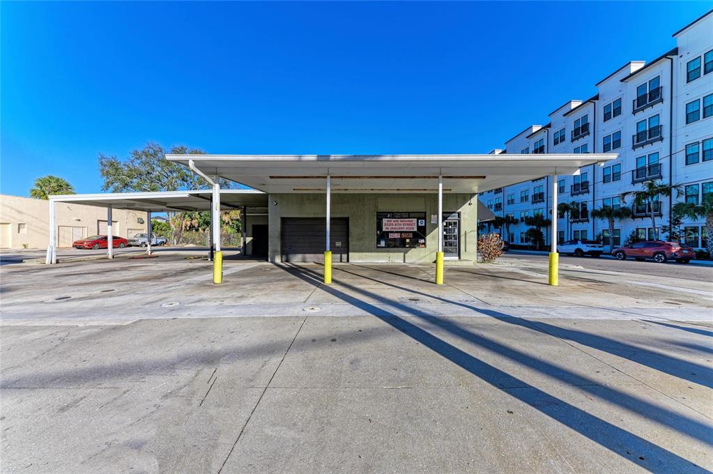 An exterior view of a commercial building with a large covered parking area — 400 W CENTRAL AVENUE, SARASOTA, FL