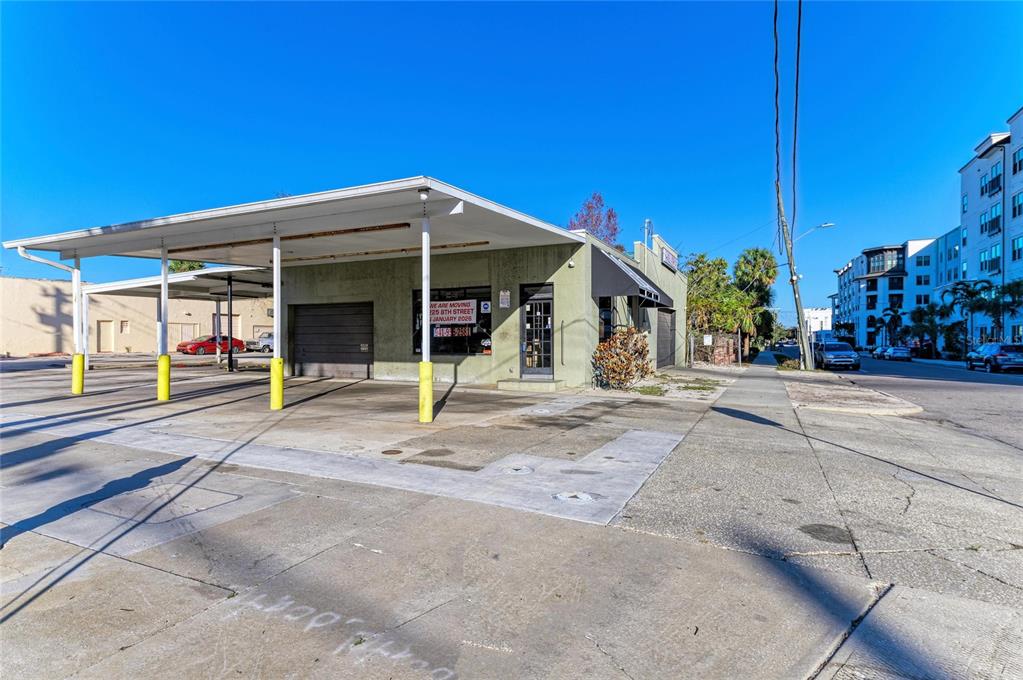 A single-story commercial building with a covered parking area and a concrete lot — 400 W CENTRAL AVENUE, SARASOTA, FL