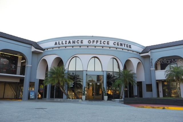 The exterior of a blue commercial building features arched entryways and the Alliance Office Center sign — 8421 S ORANGE BLOSSOM TRAIL UNIT 436, ORLANDO, FL