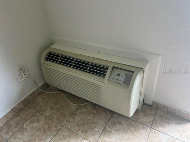 A wall-mounted PTAC air conditioning unit sits on a tiled floor against a white wall — 8421 S ORANGE BLOSSOM TRAIL UNIT 436, ORLANDO, FL