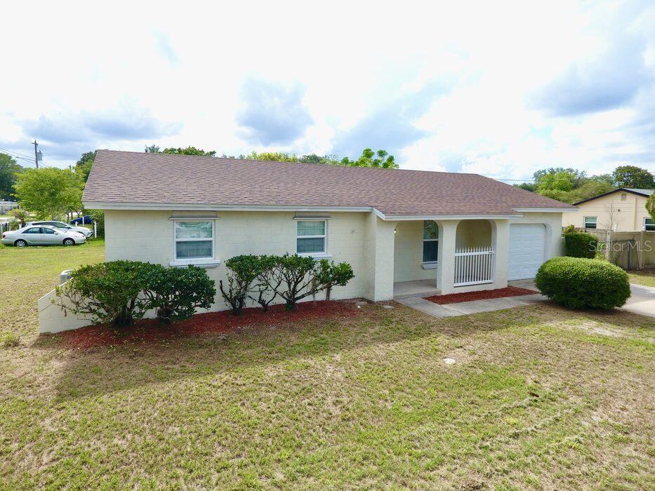 A single-story house with a light-colored block exterior, a shingled roof, and a front porch — 2202 MURDOCK BOULEVARD, ORLANDO, FL