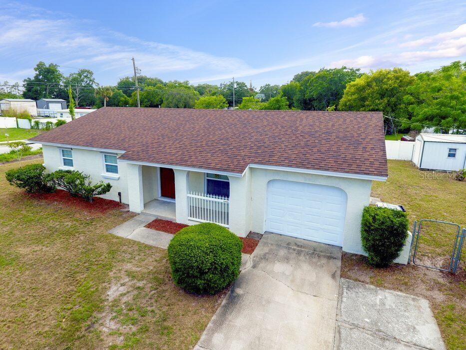 An exterior view of a single-story house with a white facade, brown roof, and garage — 2202 MURDOCK BOULEVARD, ORLANDO, FL