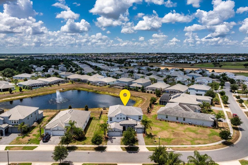 An aerial view shows a two-story house with a yellow location marker near a pond — 1432 OLYMPIC CLUB BOULEVARD, CHAMPIONS GATE, FL