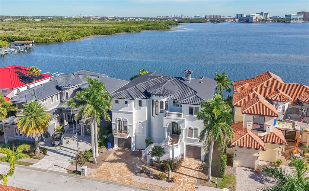 An aerial view shows a white multi-story house with a dark roof near the water — 4107 CAUSEWAY VISTA DRIVE, TAMPA, FL