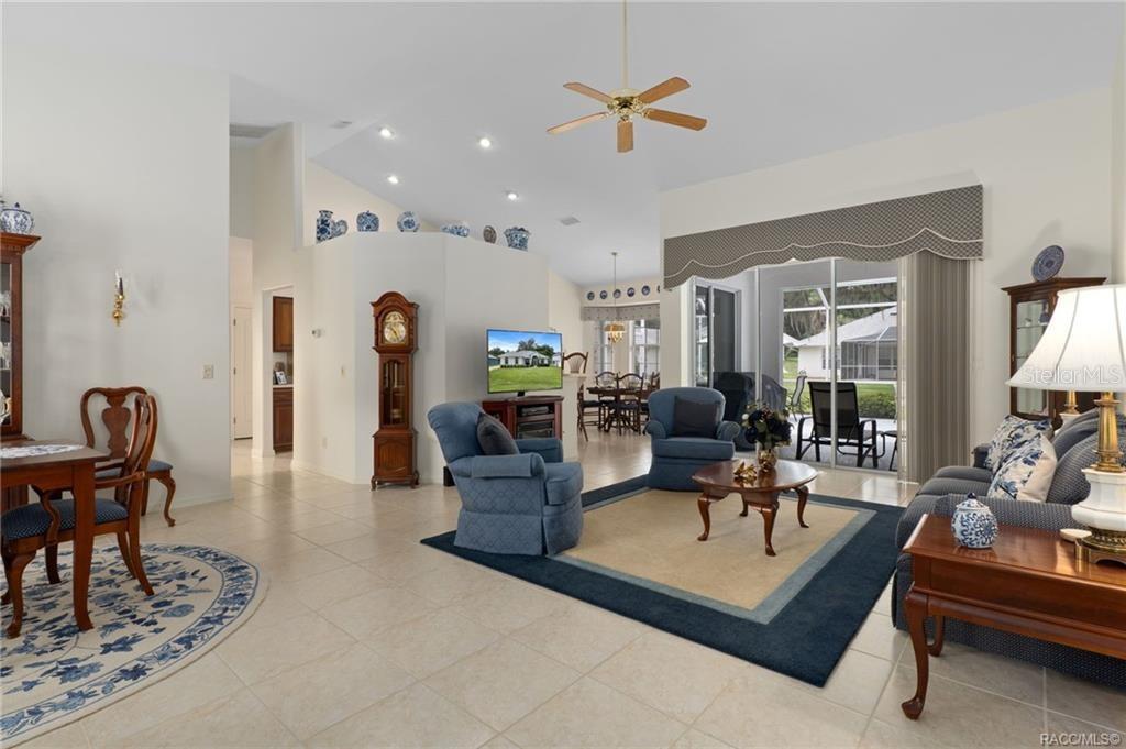 A living room with tile floors, a blue area rug, and a sliding glass door — 2786 N CANTERBURY LAKE DRIVE, HERNANDO, FL