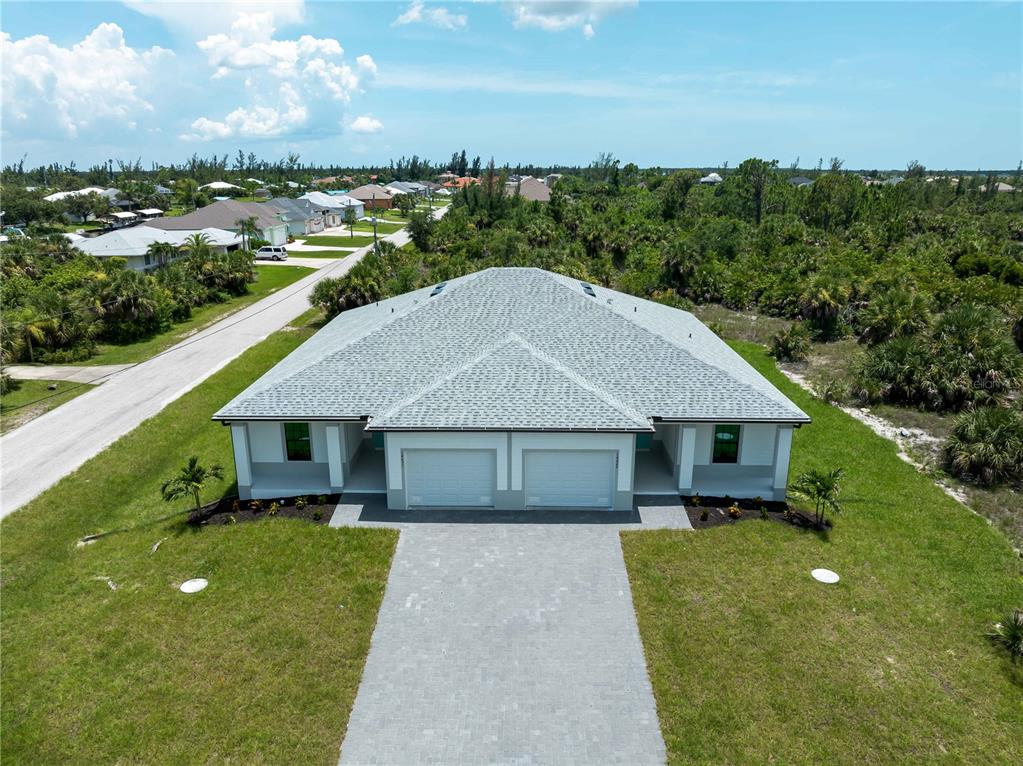 An aerial view of a newly constructed duplex with a gray shingled roof and driveway — 14449 & 14451 APPLETON BOULEVARD, PORT CHARLOTTE, FL