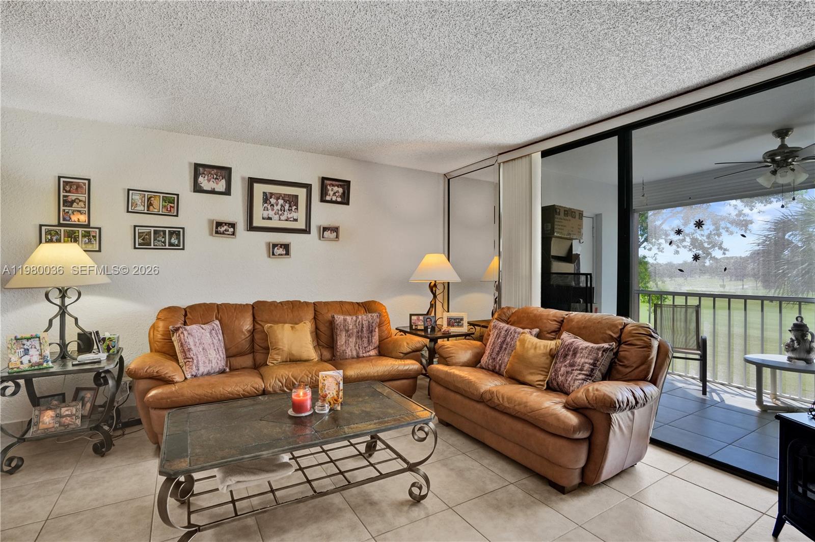 A living room features two brown leather sofas, a coffee table, and a balcony view — 7400 NW 18th St # 204, Margate FL 33063, MARGATE, FL