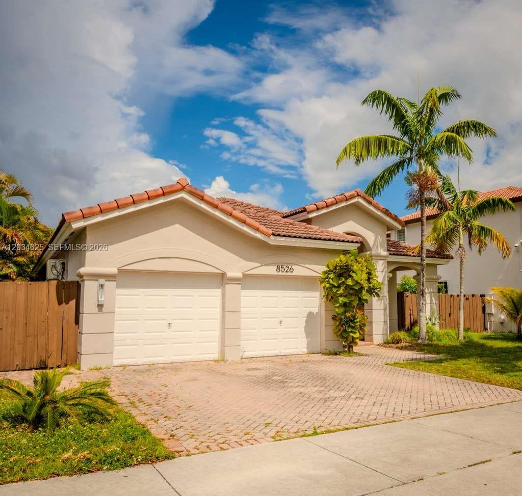 A single-story house with a two-car garage, tile roof, and palm trees in the front — 8526 NW 110th Pl # 0, Doral FL 33178, DORAL, FL
