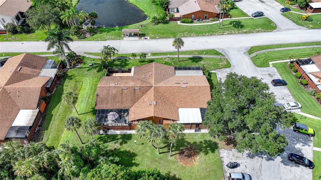 An aerial view shows a residential house with a brown roof and screened-in patio — 5625 FOXLAKE DRIVE, NORTH FORT MYERS, FL