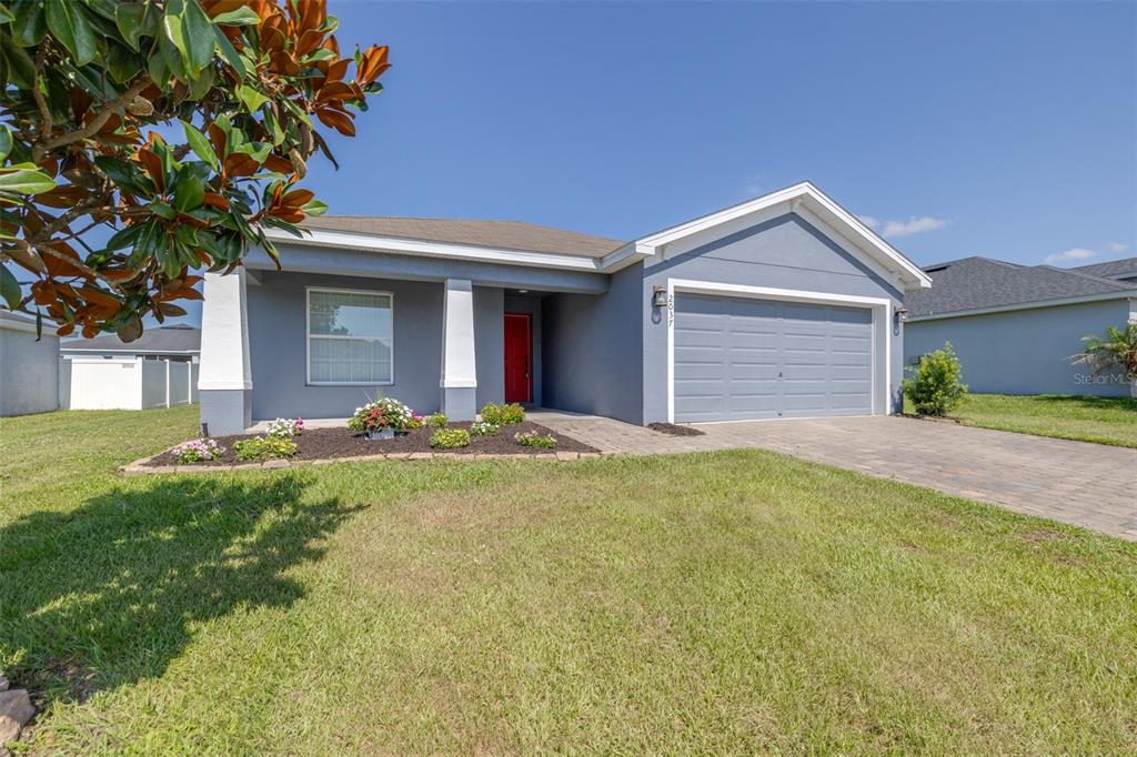 A single-story house with a gray exterior, a red front door, and a two-car garage — 2037 CHARLESTON LANE, BARTOW, FL