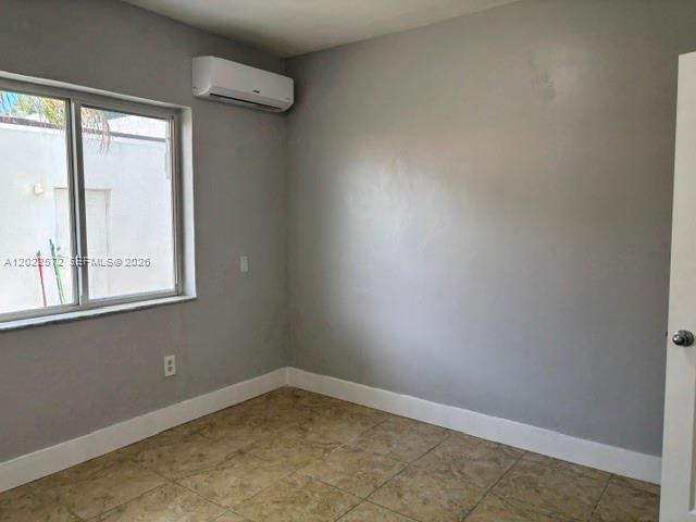 A bedroom with gray walls, tile flooring, a window, and a wall-mounted air conditioner — 2059 SW 7th St # 0, Miami FL 33135, MIAMI, FL