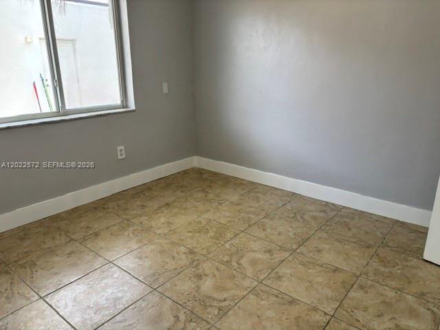 An empty room features light gray walls, white baseboards, and tan tiled flooring — 2059 SW 7th St # 0, Miami FL 33135, MIAMI, FL