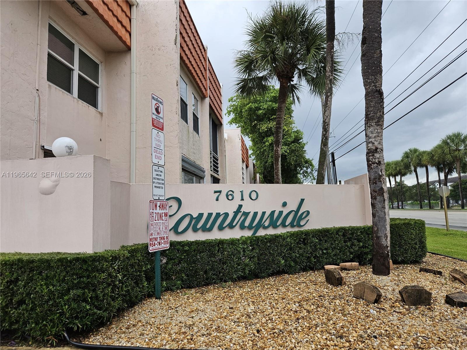 The exterior of a residential building features a sign reading Countryside with palm trees nearby — 7610 Stirling Rd # 102C, Davie FL 33024, DAVIE, FL