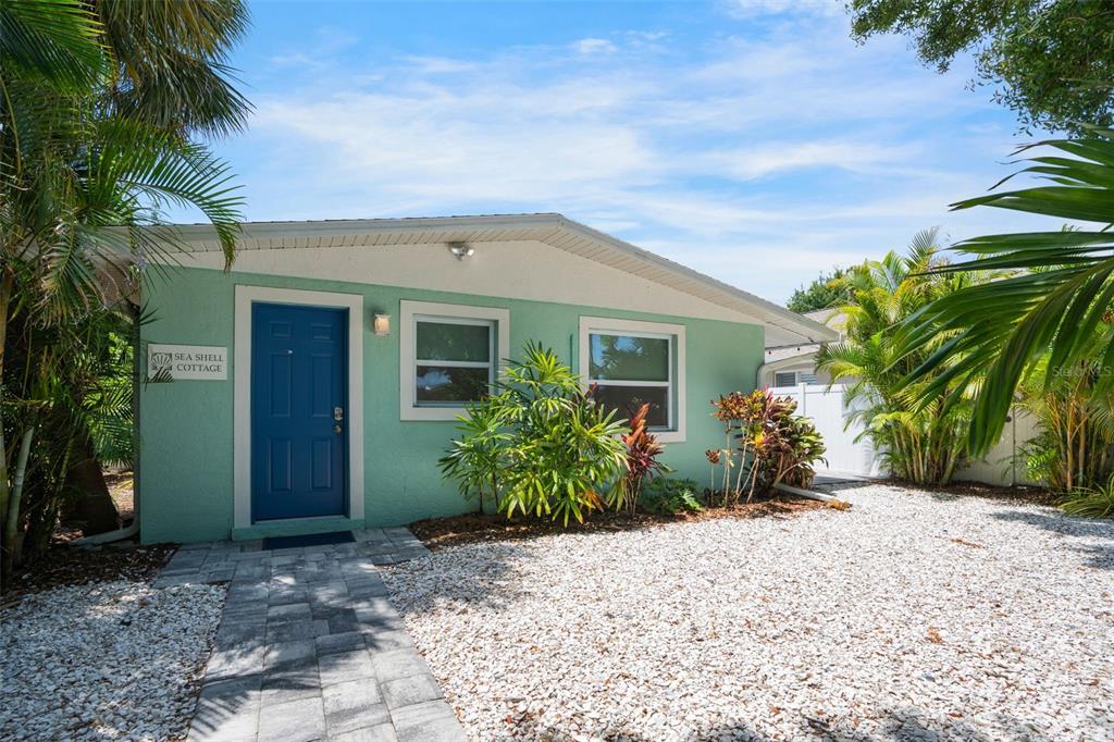 A light green cottage with a blue front door and a white gravel front yard — 2053 ROSELAWN STREET, SARASOTA, FL