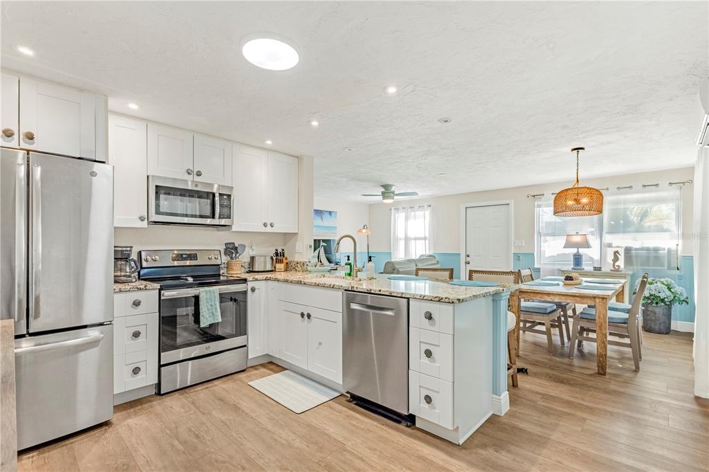 A kitchen with white cabinets, stainless steel appliances, and a granite island countertop — 2053 ROSELAWN STREET, SARASOTA, FL