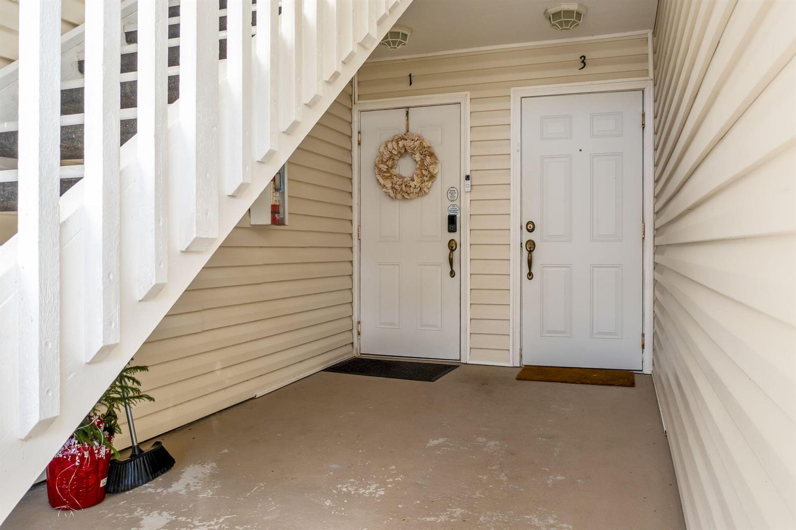 An exterior view shows two white apartment doors labeled 1 and 3 under stairs — 1940 Westminster Circle # 1, Vero Beach FL 32966, VERO BEACH, FL