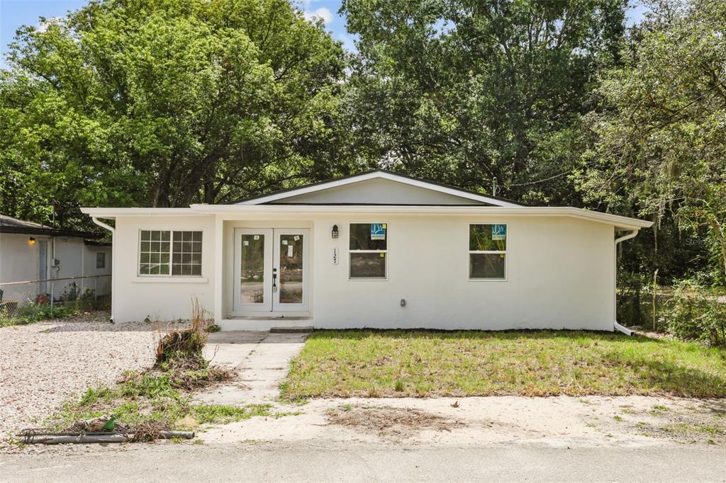 A single-story house with white stucco walls, a light-colored roof, and a double-door entrance — 127 LEON STREET, ALTAMONTE SPRINGS, FL