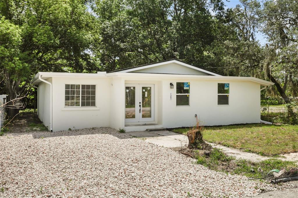 A single-story white house with a gravel driveway and double front doors — 127 LEON STREET, ALTAMONTE SPRINGS, FL