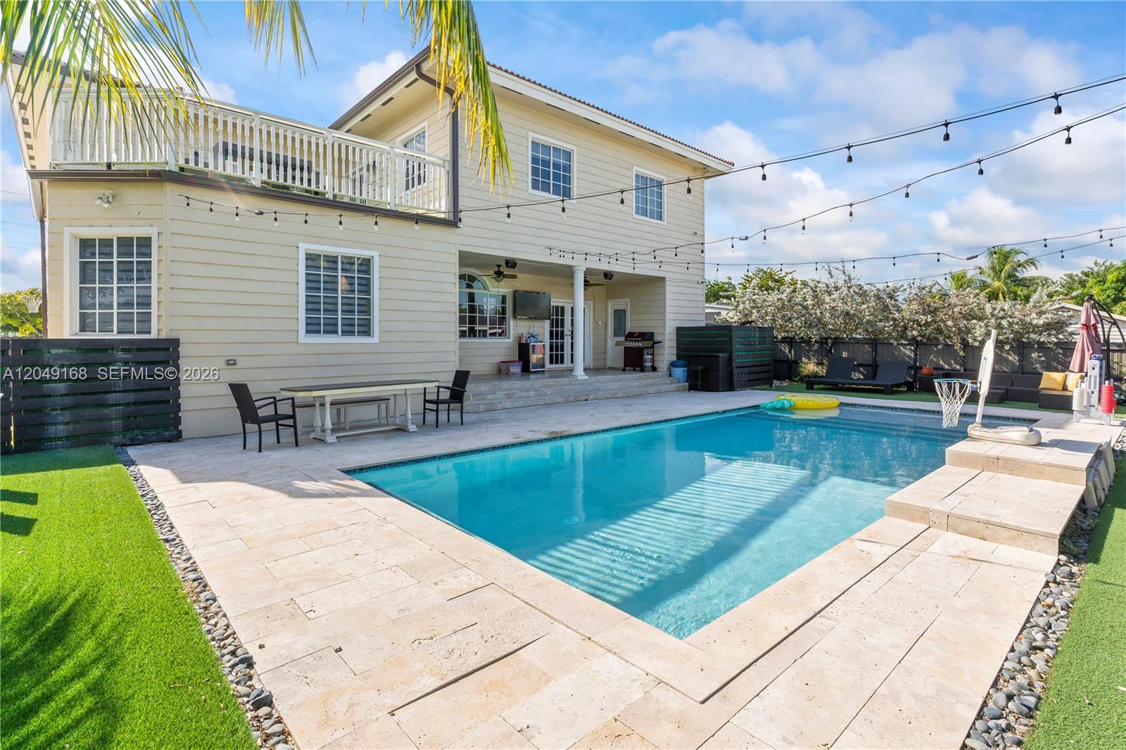 A two-story house with a backyard pool, patio, and string lights overhead — 901 Dove Ave, Miami Springs FL 33166, MIAMI SPRINGS, FL