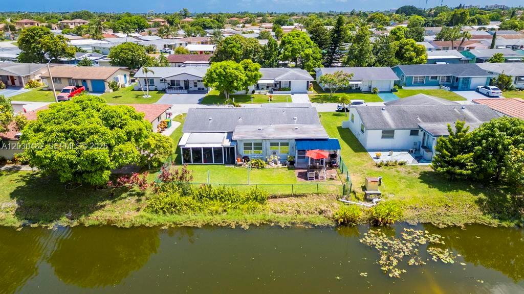An aerial view shows a single-story house with a backyard facing a canal — 4923 NW 55th Ct, Tamarac FL 33319, TAMARAC, FL