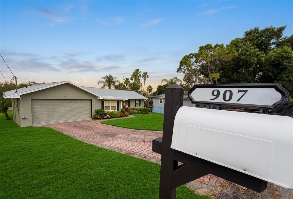 A single-story house with a brick driveway and a mailbox in the foreground — 907 VALENTINA DRIVE, DUNDEE, FL