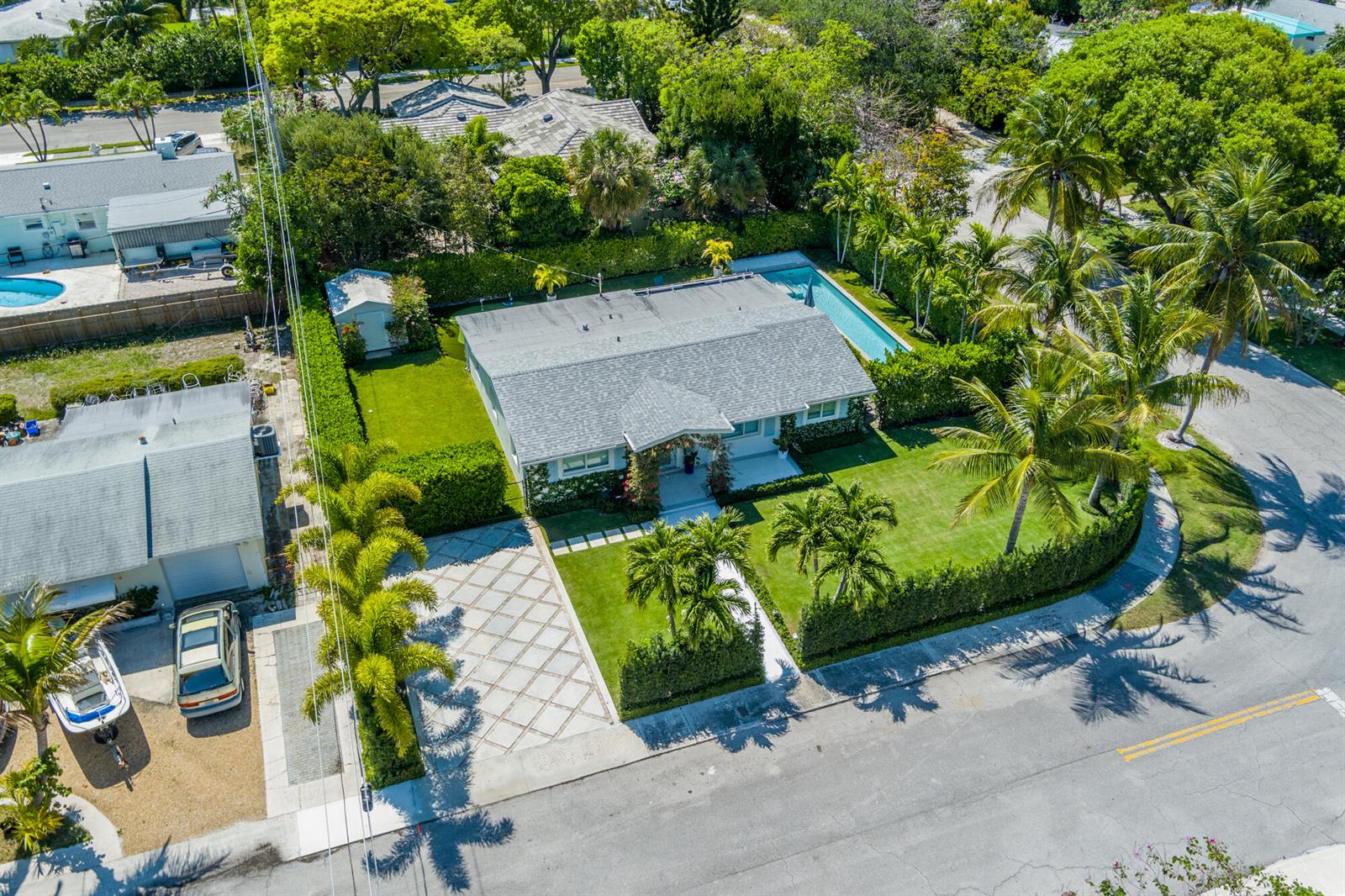 An aerial view shows a single-story house with a pool, palm trees, and paved driveway — 8001 Arlington Place, West Palm Beach FL 33405, WEST PALM BEACH, FL