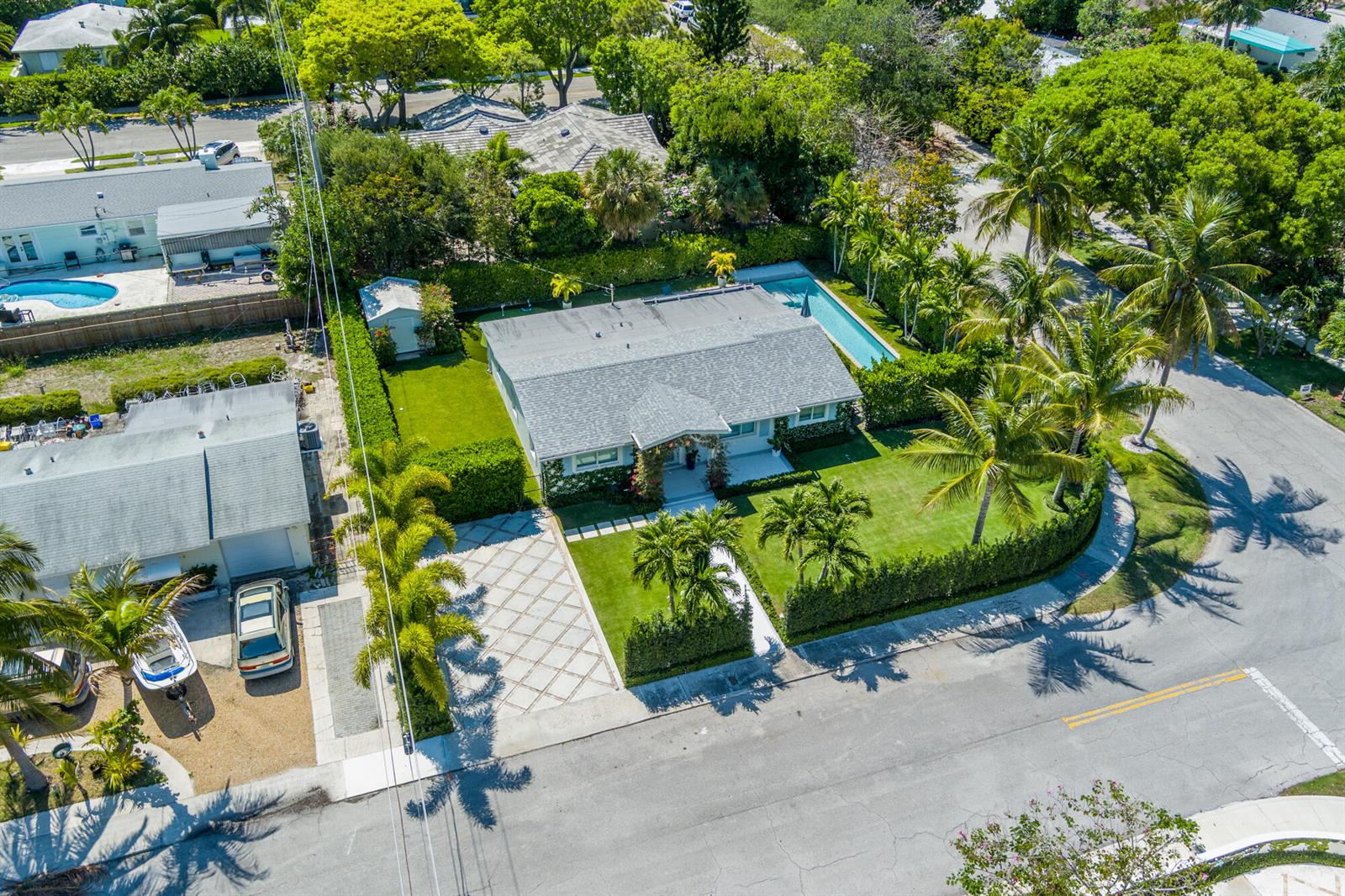 An aerial view shows a single-story house with a pool, lawn, and patterned driveway — 8001 Arlington Place, West Palm Beach FL 33405, WEST PALM BEACH, FL