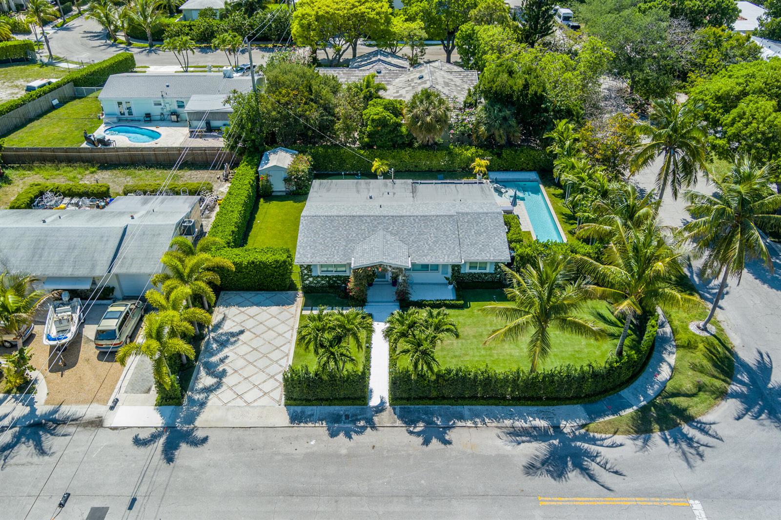 An aerial view shows a single-story house with a pool, driveway, and landscaped yard — 8001 Arlington Place, West Palm Beach FL 33405, WEST PALM BEACH, FL
