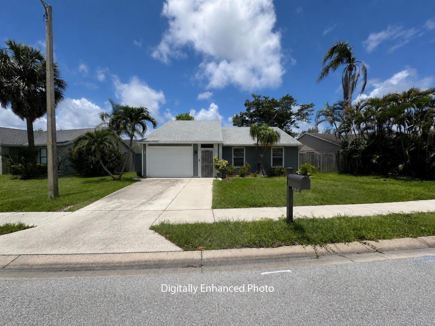 A single-story house with a white garage, gray siding, and palm trees in the front yard — 132 Timberline Drive, Jupiter FL 33458, JUPITER, FL