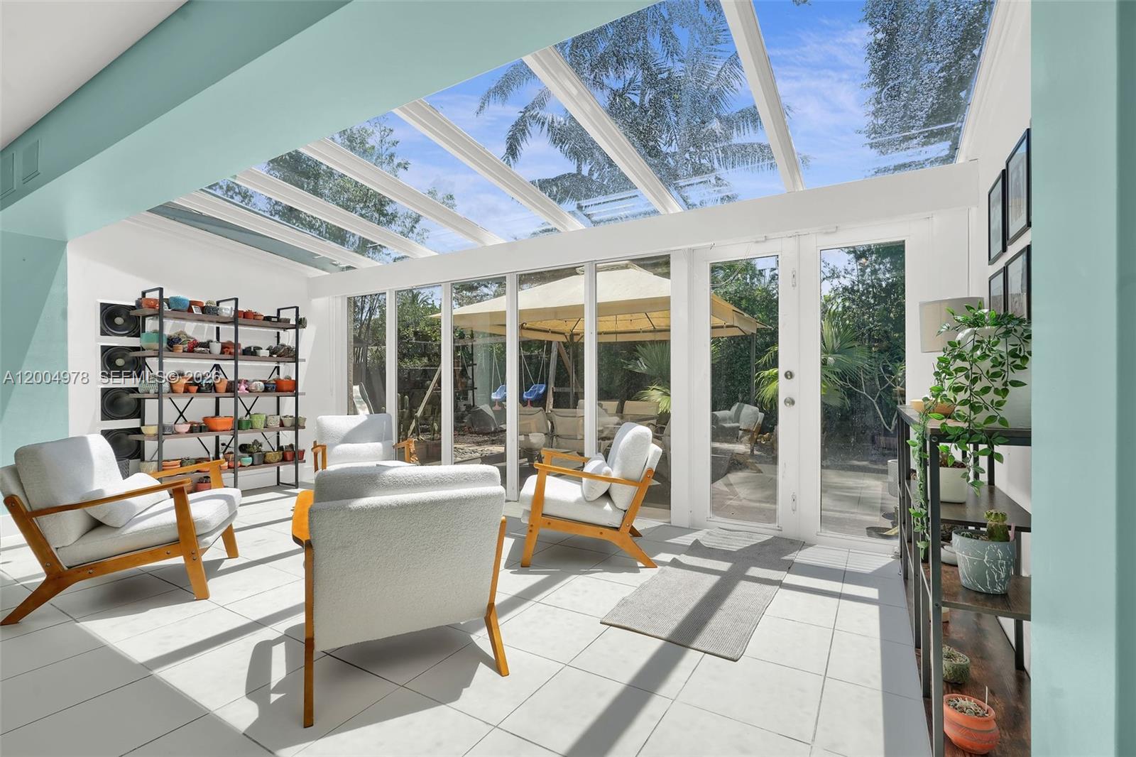 A sunroom features a glass roof, white tile floors, and glass doors leading to a patio — 15540 SW 152nd Ter, Miami FL 33187, MIAMI, FL