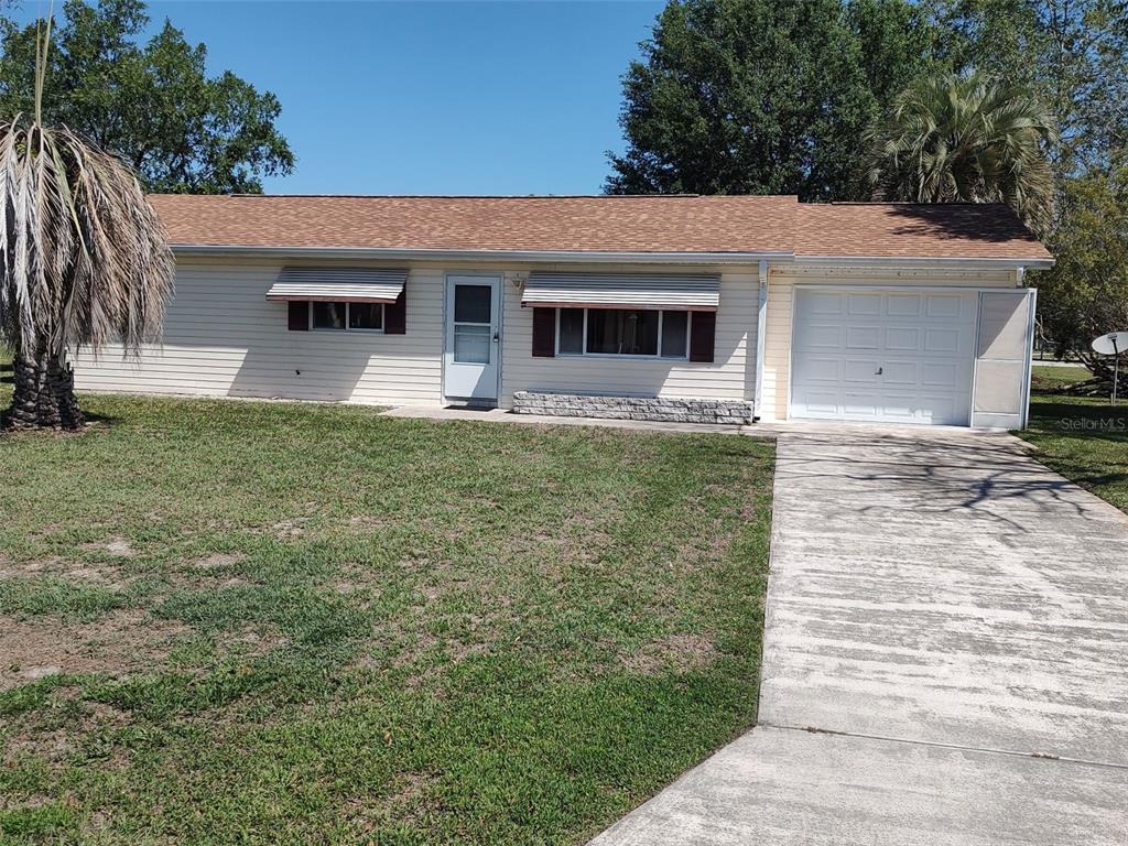A single-story house with light siding, a brown roof, and an attached garage — 6345 SW 115TH STREET ROAD, OCALA, FL