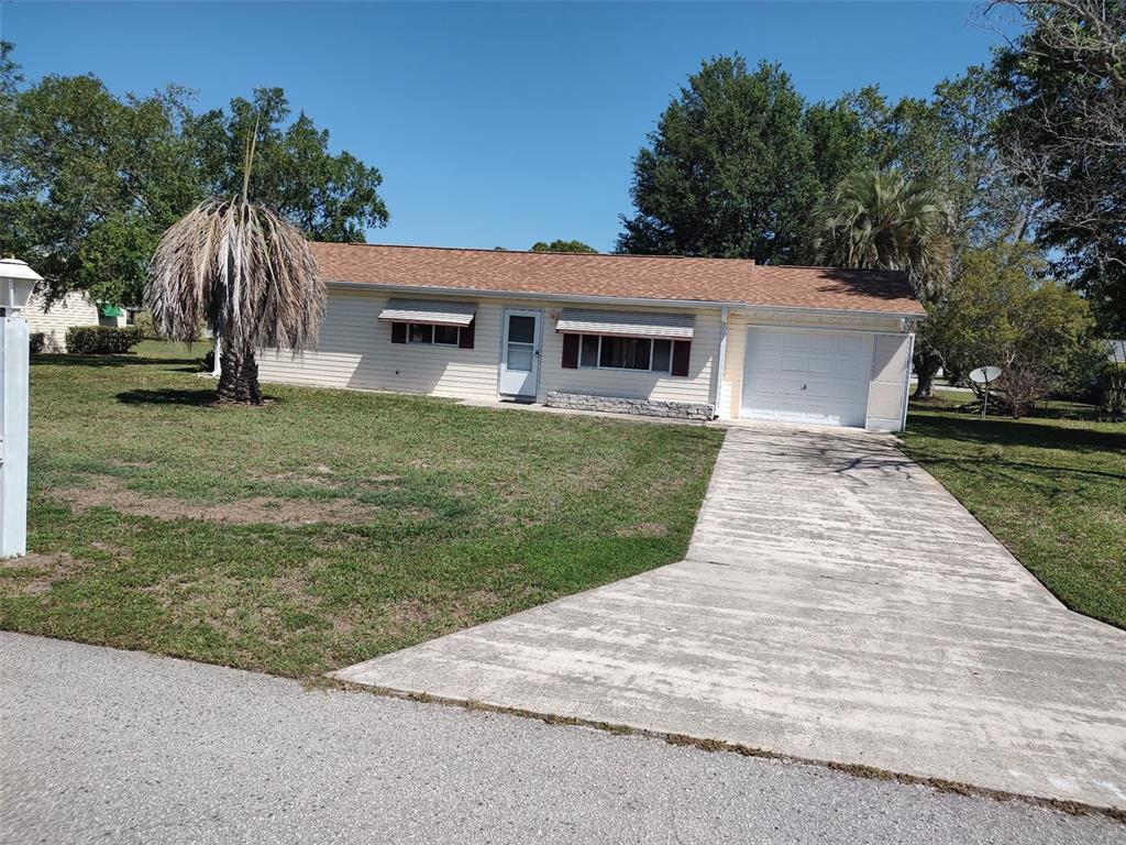 A single-story house with light siding, a brown roof, and an attached one-car garage — 6345 SW 115TH STREET ROAD, OCALA, FL