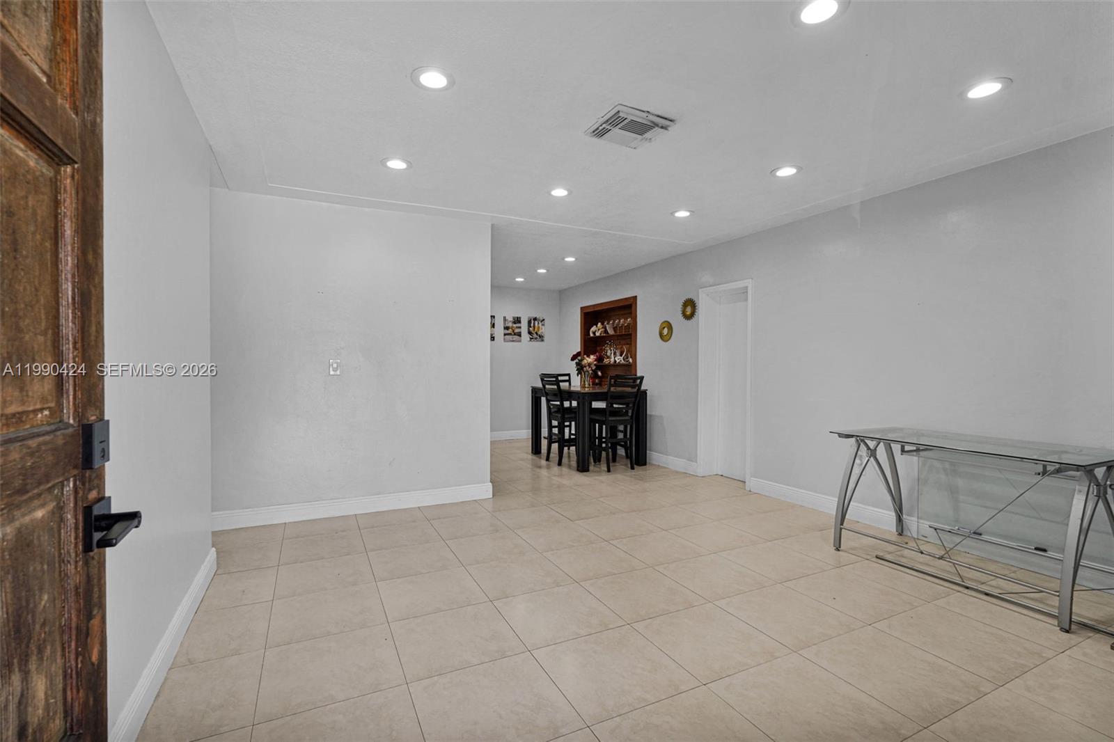 A room with light-colored tile flooring, recessed lighting, and a dining area in the background — 760 E 55th St, Hialeah FL 33013, HIALEAH, FL