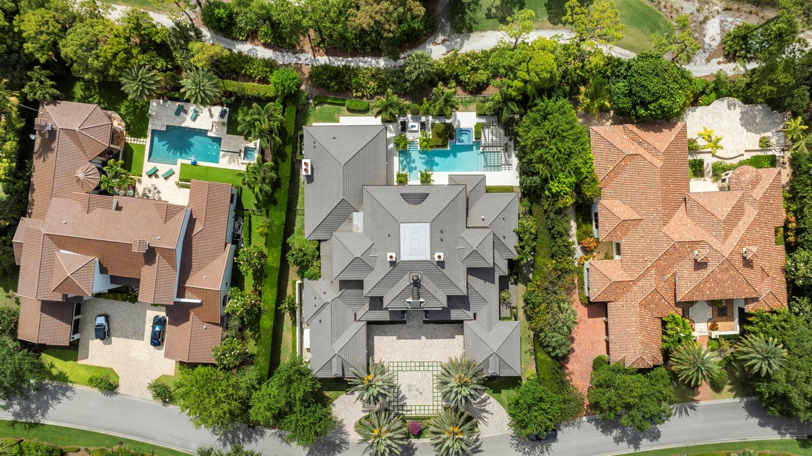 An aerial view shows three large houses with tiled roofs, swimming pools, and landscaped yards — 131 W Bears Club Drive, Jupiter FL 33477, JUPITER, FL