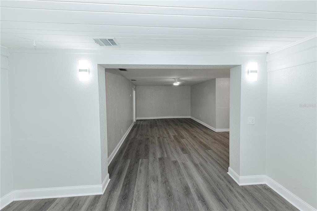 A room with grey wood-look flooring and a wide opening leading to another space — 2240 10TH STREET S, ST PETERSBURG, FL