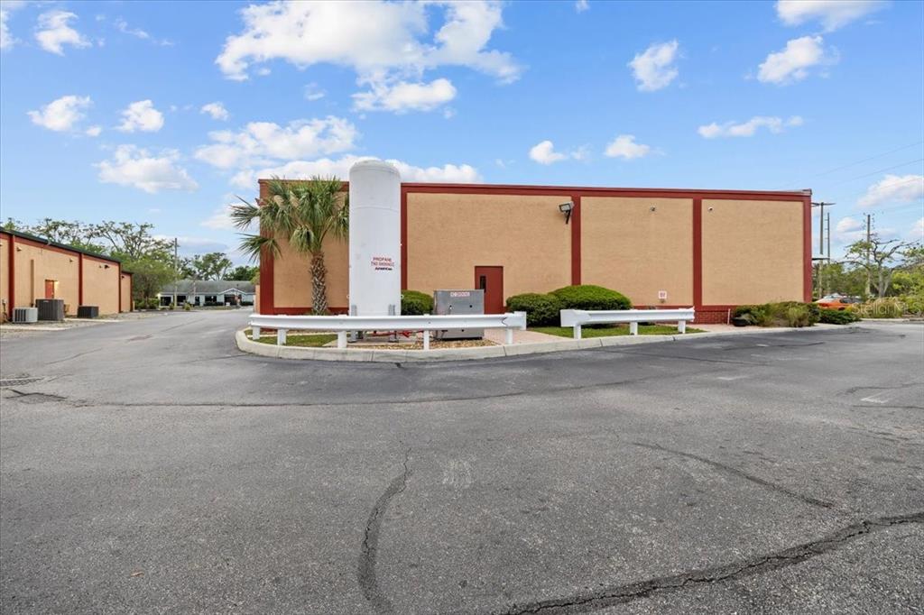 A large propane tank stands in front of a commercial building with a paved parking lot — 3684 TAMPA ROAD UNIT 101, OLDSMAR, FL