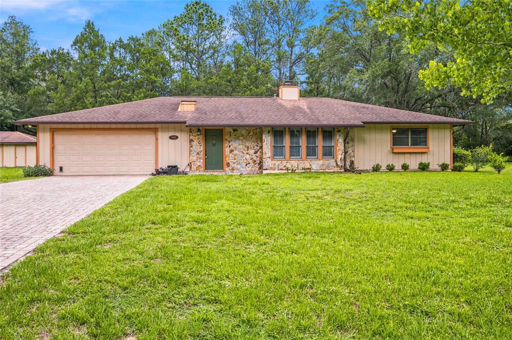A single-story house with a stone facade, green front door, and attached two-car garage — 5143 SE 17TH STREET, OCALA, FL
